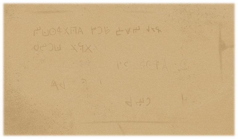 Eroded letters carved against the stone walls of the building. Eroded letters carved against the stone walls of the building. The first few words are legible, but the rest are not.